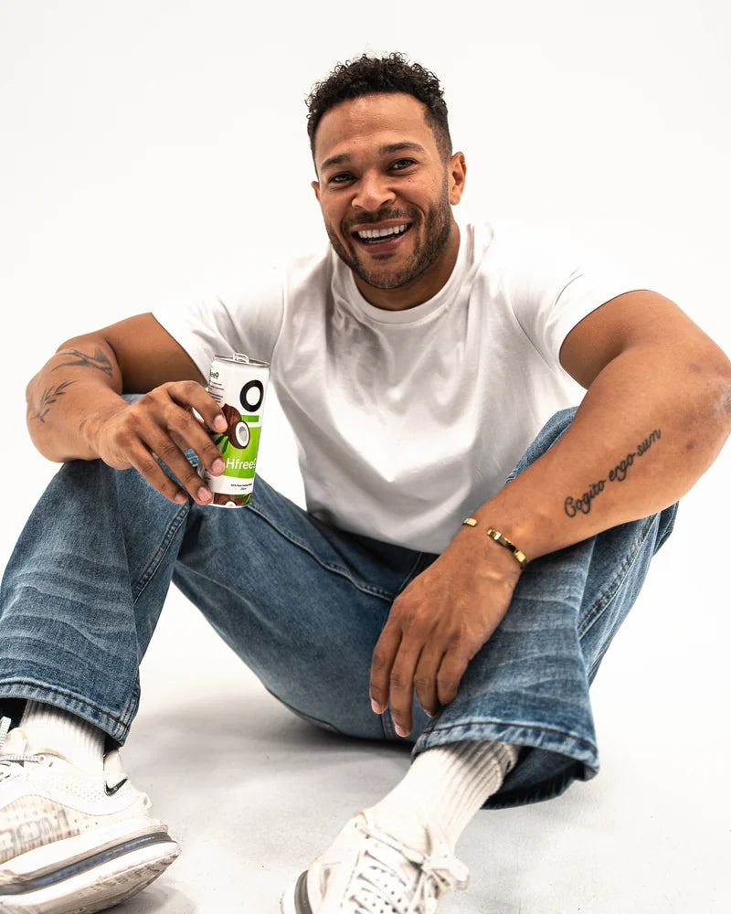 Cole Anderson-James sat on the studio floor, smiling, with a can of HfreeO
